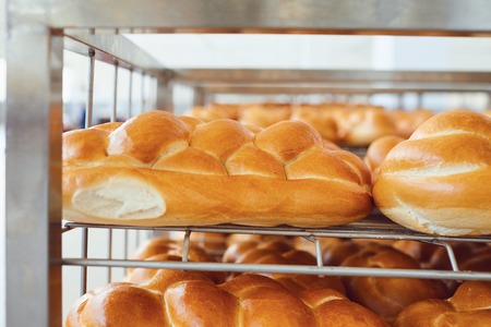 Tray with fresh brown bread at the bakery. Baking fresh bread in the oven at the factory.