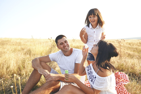 Happy family sitting on the grass on the nature in summer, autumn.の写真素材