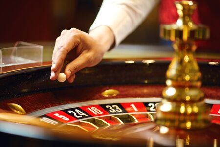 The croupier holds a roulette ball in a casino in his hand. Gambling in a casino.の写真素材