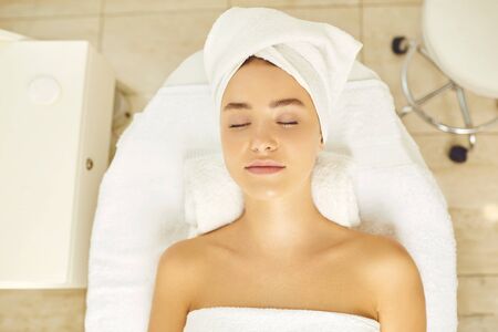 Facial skincare. Facial rejuvenation.Face of a beautiful girl before cosmetic procedures. Brunette girl lying on a massage desk.の写真素材