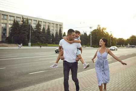 Happy smiling family walking on the street. The family spends free time together.の写真素材