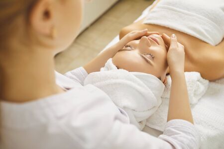 Face woman massage relax close up. Facial massage to a beautiful girl lying in a beauty clinic.Cosmetology skin care.の写真素材