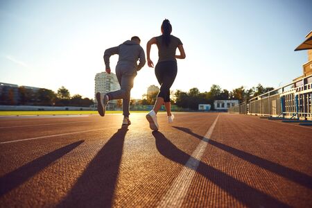 Couple running in the morning for health.Back view. Athletic couple runs in the morning at the...