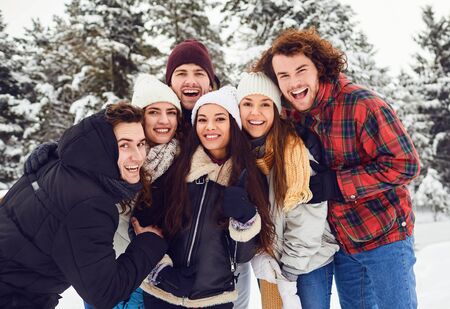 Group of friends smiling in the park in winterの写真素材