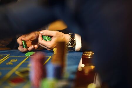 Chips in the hands of a player in a casino. Gambling poker roulette in casino.の写真素材