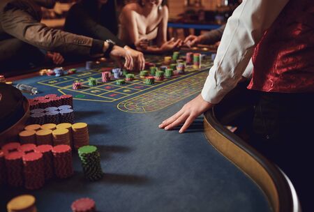 People gambling at roulette poker table in a casino.