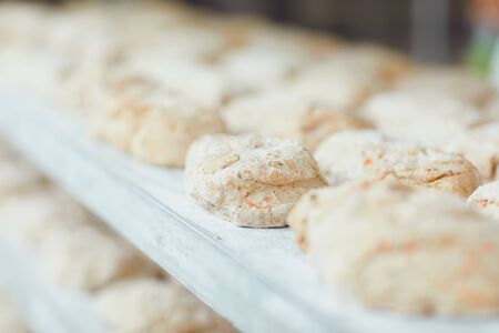 Raw bread on trays before baking in the oven at the bakery factory.