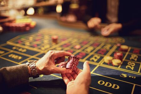 Chips in the hands of a player in a casino. Gambling poker roulette in casino.の写真素材