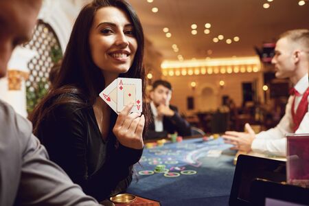 Girl with cards in her hands smiles rejoices at winning poker in a casino. Gambling Betting. Roulette.の写真素材