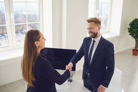 Handshake of business people. Businesspeople hold each others hands while standing in a meeting at office. The conclusion of the contract by business people.の写真素材