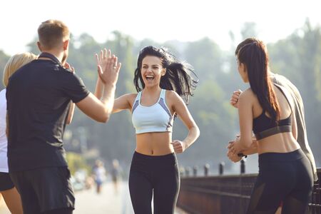 Girl runner runs fun with a group of friends in a park in the morning in the summer in autumn. Active lifestyle. Jogging. Health. Healthy lifestyle.の写真素材