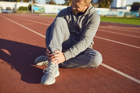 Knee injury in training. Man injured his leg during exercise. Injury while running. Knee pain.の写真素材