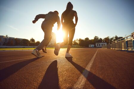 Running in the morning for health.Back view. Athletic couple runs in the morning at the stadium. Jogging during training.Jogging. Health. Healthy lifestyle.の写真素材