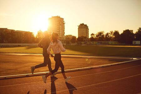 Running in the morning for health. Athletic couple runs in the morning at the stadium. Jogging...