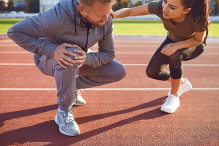 Knee injury in training. A male injured his leg during exercise. Injury while running. Knee pain.の写真素材