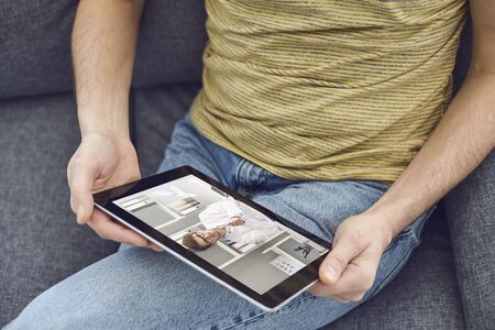 Online medical consultation for patients. Doctor man webcam video call using tablet talks with male...