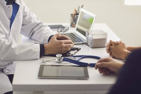 Confident doctor and couple patient sitting at the table in clinic office. Family doctor. Doctor consultation prescription diagnosis meeting with patient. Health care medicine medical care. Family planning.の写真素材