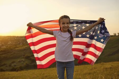 Patriotic holiday Independence Day of America.Kid girl child with American flag celebrates Independence Day.の写真素材