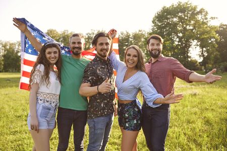 A group of happy young people have fun celebrating Americas Independence Day. Patriotic celebration...