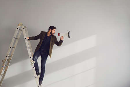 Businessman on the stairs with a megaphone in hand shouts