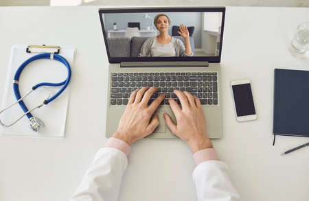 Online doctor topview. Senior woman waving hand on laptop screen.Mature woman using video call to her doctor. Modern telemedicine.の写真素材