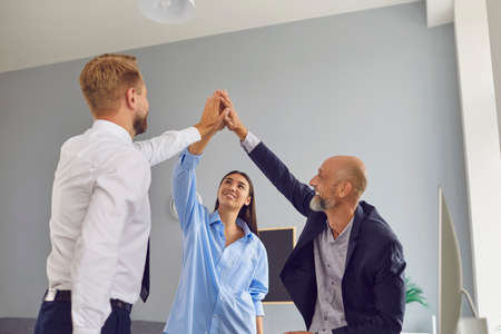 Well done. Happy diverse team celebrating successful deal, business partnership or project...