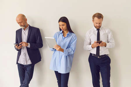 Diverse old and young people waiting in queue searching information, communicating, playing games, killing time online. Men using phones. Woman watching video on tablet. Gadget addiction conceptの写真素材