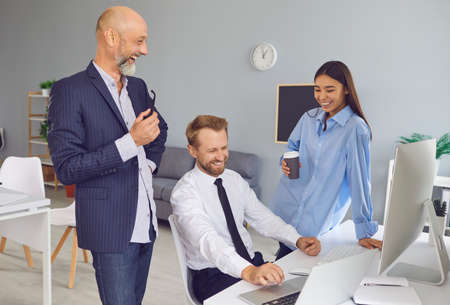 Coffee break in diverse workplace. Positive attitude to work. 3 company employees talking, laughing,...