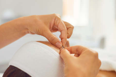 Close-up of cosmetologists hands making lifting massage movements on womans face and eyebrows in...