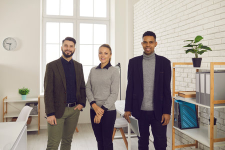 Group portrait of three diverse business people looking at camera. Team of happy smiling young...