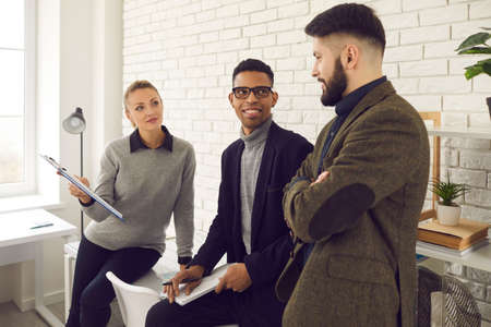 International business team, success, multiethnic group concept. Group of young positive black and caucasian business partners discussing project together in officeの写真素材