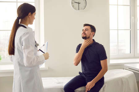 Patient is sitting on an examination bed in a medical clinic and complains to the doctor about flu...
