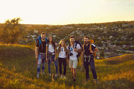 Portrait of a company of young active friends of boys and girls hiking in the mountainous...