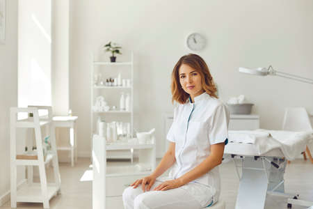 Woman cosmetologist or dermatologist looking at camera in beauty spa salon roomの写真素材