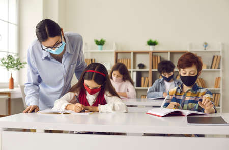 Back at school with safety measures against coronavirus respiratory infection. Students and teacher...