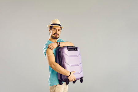Guy in a hat with a suitcase in his hands shows his hand with a   the spot of the vaccine injection.の写真素材