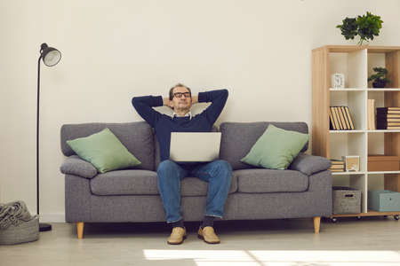 Calm mature man with eyes closed sleeping or napping relaxing on comfortable lounge couch with...