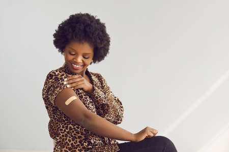 Vaccination and immunization during pandemic time. Happy vaccinated african american woman looking...