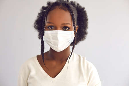 Close up headshot of young responsible citizen wearing disposable surgical face mask.の写真素材