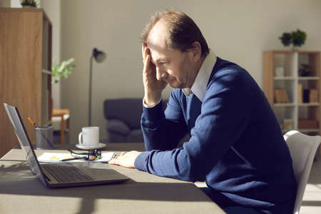 Businessman receives business email with bad news. Lagging computer hangs and gets stuck due to...