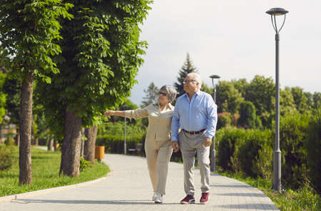 Active senior old couple walking in park talking enjoy time together. Older caucasian family staying in love spend day together. Elder healthy leisure lifestyle concept. Happy retirement and pleasureの写真素材