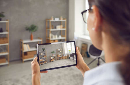 Woman who plans on selling her studio apartment taking photo of stylish decor in custom design...