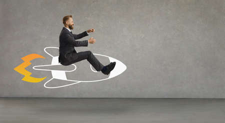 Side profile view happy smiling laughing man flying in air riding cartoon doodle rocket with burning...