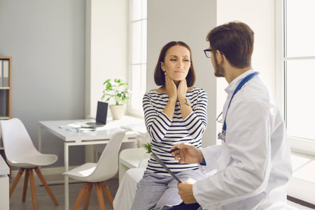 Lady with inflamed tonsil glands visits doctor at clinic. Worried woman asks specialist to help...