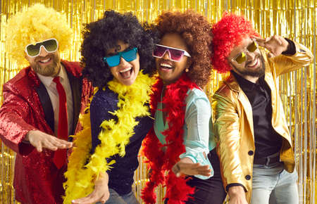 Bunch of excited young friends having fun together. Diverse group of happy people in boas, cool...