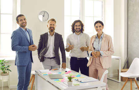 Team of creative business people during work meeting. Group portrait of happy young corporate...