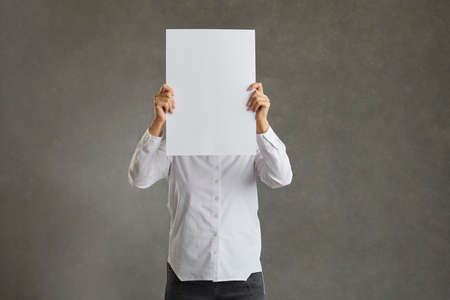 Business man holding up a banner against a white background instead of his head. Cardboard placard...