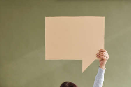 Close up crop of woman hold speech bubble with copy space show good sale deal or promotion discount. Person make advertising announcement demonstrate offer. Green studio background, copyspace.の写真素材