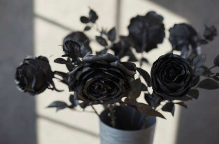 Close up shot of a bouquet of beautiful black roses. Closeup of a bunch of dark, lifelike, long stem flowers put in a grey vase as an interior decor detail, a romantic present, or a party decorationの写真素材