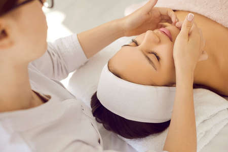 Close up of cosmetologist make rejuvenating face procedures for woman client in spa or saloon. Beautician do facial lifting massage to patient in aesthetic medicine clinic. Beauty, cosmetology.の写真素材